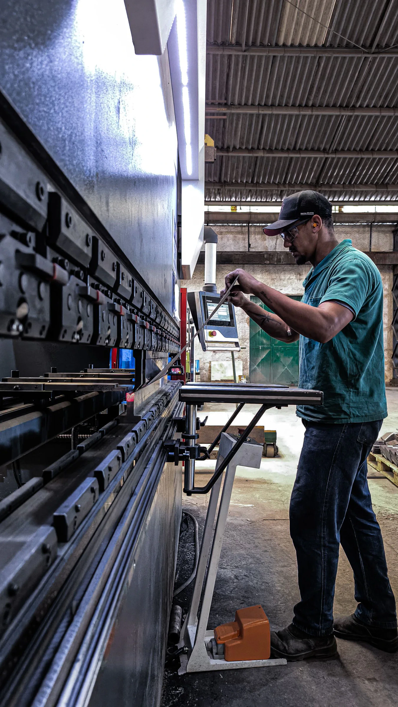Opérateur réalisant le pliage précis d’une pièce métallique en atelier