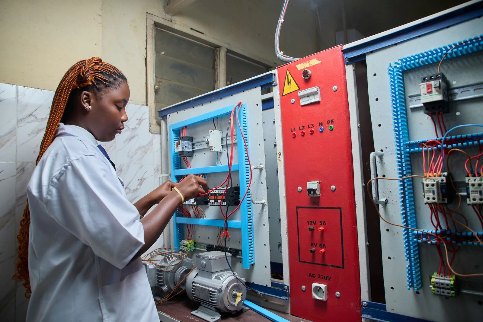 Technicienne travaillant sur une armoire électrique industrielle